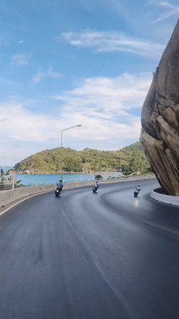 Motorbike riders travel scenic coastal road in Thailand