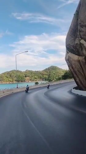 Motorbike riders travel scenic coastal road in Thailand