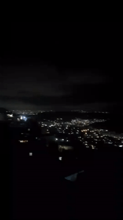 Caracas glows at night from above, lights across the valley