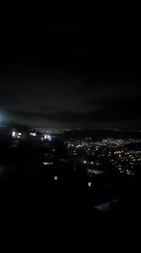 Caracas glows at night from above, lights across the valley