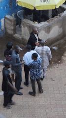 People gather for conversation in outdoor paved area