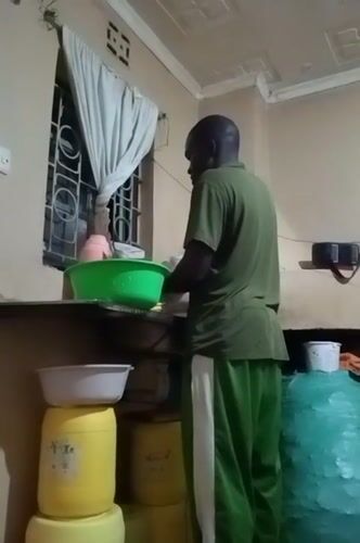 Man cooks and cleans in kitchen in Turbo, Kenya