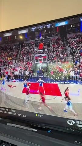 The video shows a television screen displaying a basketball game, specifically a WNBA game between the Indiana Fever and the Las Vegas Aces. The game is being played in front of a large crowd. Players on both teams are visible, moving around the court. The game clock shows 5:05. The screen also displays the score, with the Fever trailing the Aces 31 to 40. A sports ticker at the bottom of the screen shows the NHL game between the Avalanche and Wild. There are other sports leagues listed as well, NBA, MLB, and UFL.