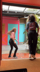 Women dance outside colorful building in São Paulo