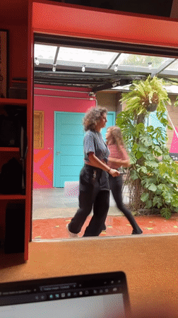 Women dance outside colorful building in São Paulo