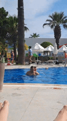 Tourist relaxes poolside at Kuşadası resort on sunny afternoon