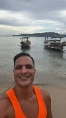 Lazy morning on Chalong beach with boats, people, and a wet dog