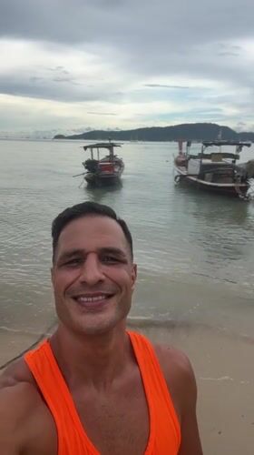 Lazy morning on Chalong beach with boats, people, and a wet dog