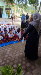 School children gather outdoors in Simpangjaya courtyard