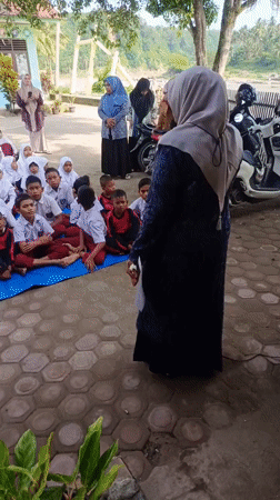 School children gather outdoors in Simpangjaya courtyard