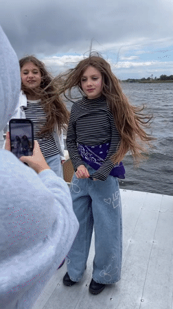 Girls filming on boat near Vyshenky Ukraine waterway
