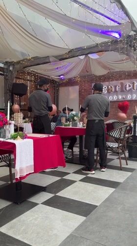 Rooftop restaurant celebration with heart balloons overlooks Kuala Lumpur skyline