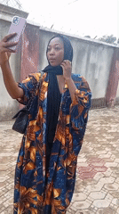 Woman takes selfie with purple phone in Rido, Nigeria