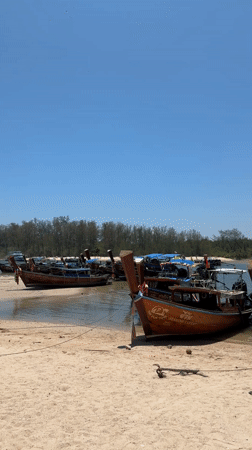 Longtail boats dock at Thai beach passenger area