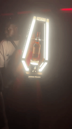 Woman takes whiskey bottle from display in Abuja nightclub