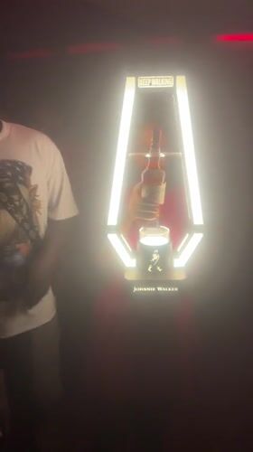 Woman takes whiskey bottle from display in Abuja nightclub