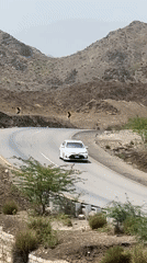 Traffic moves through a winding mountain road in arid Pakistan