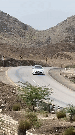 Traffic moves through a winding mountain road in arid Pakistan