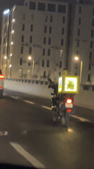 Delivery motorcycle rolls through Dhahran at night