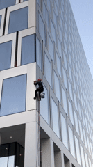Rappelling window cleaner works a Moscow high-rise facade at dusk