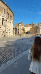 Woman walks past ancient ruins in Rome morning scene