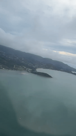 Passenger films aerial view over Thailand waters from airplane window