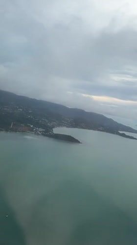 Passenger films aerial view over Thailand waters from airplane window