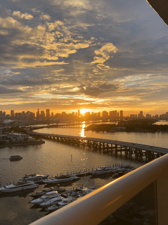 Woman takes selfies on Miami Beach walkway wearing tennis cap