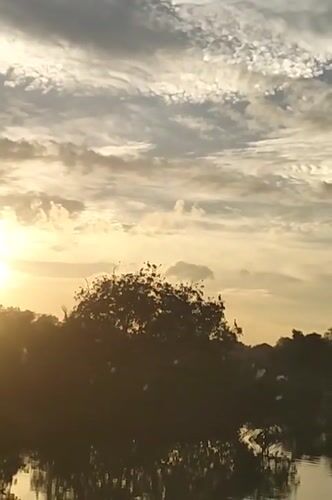 Sunset captured over waterways and villages in Lhokseumawe, Indonesia