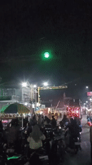 Nighttime street parade with decorated floats and fireworks