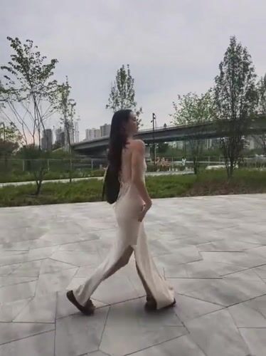 Woman in cream dress moves through Tyumen park locations