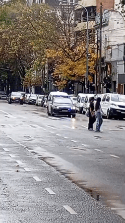 Police vehicle with flashing lights observed on wet Buenos Aires street