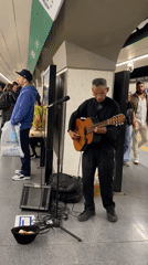 Street musician performs guitar in Buenos Aires subway station