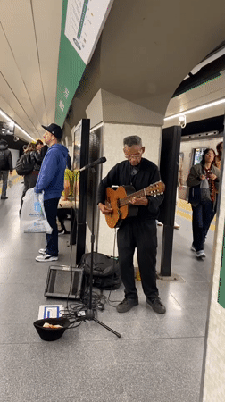 Street musician performs guitar in Buenos Aires subway station