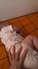 Baby rests on plaid blanket in Berezovyi home