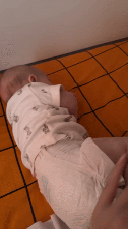 Baby rests on plaid blanket in Berezovyi home