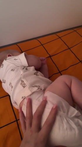Baby rests on plaid blanket in Berezovyi home
