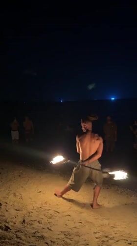Fire spinner performs nighttime beach show in Thailand