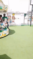 Children play at artificial turf playground while DJ performs