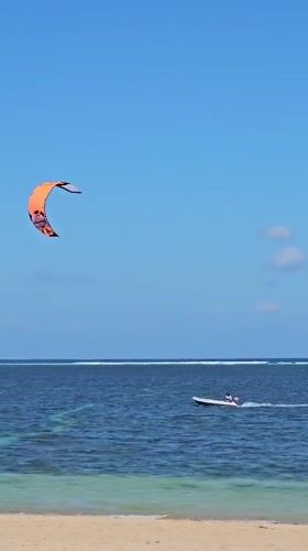 Kitesurfers work the water off Denpasar's coast