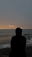 Solitary figure contemplates ocean at dusk in Lhokseumawe