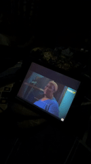 Person watches tablet videos in dark room