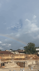 Stadium construction in Jos, Nigeria, under a rainbow sky