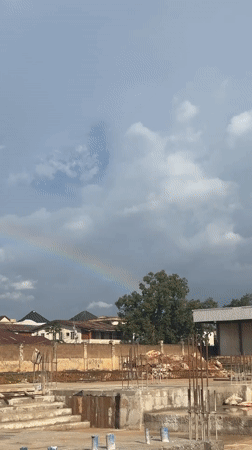 Stadium construction in Jos, Nigeria, under a rainbow sky