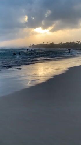 Sri Lankan beach communities enjoy sunset recreation amid dramatic skies