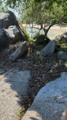 Person relaxes on rocks at Thai beach dawn