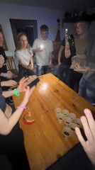 Young adults play beer pong at night party in Dunevo