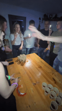 Young adults play beer pong at night party in Dunevo