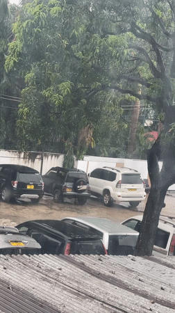 Heavy rain falls across Dar es-Salaam parking lots, streets