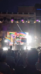 Outdoor nighttime stage performance with feathered costumes in Madrid